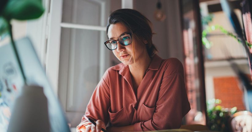Pretty young woman an advertising copywriter in eyeglasses worki
